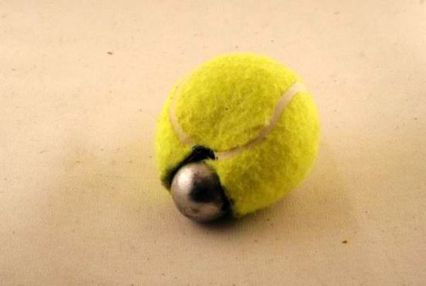 Dùng dao cắt dọc từ vị trí đánh dấu ở giữa quả bóng khoảng 2 cm. Sau đó, bạn nhét bi vào trong quả bóng.