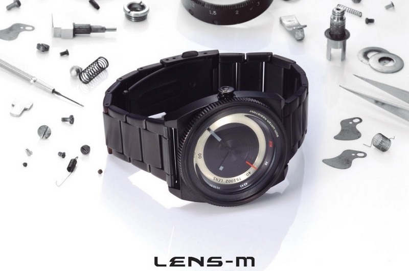 Đồng hồ Lens-M ($120) lấy ý tưởng từ máy ảnh SLR với thiết kế sắc cạnh, cùng với vòng đeo được làm từ kim loại đen sáng bóng.